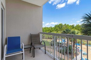 Ein Balkon mit zwei Stühlen und Blick auf einen Poolbereich, sowie ein Rauchverbot-Schild.