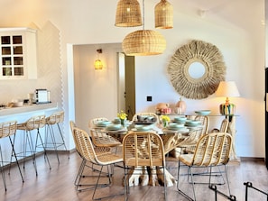 A dining area with wicker chairs, a round table, and hanging wicker lights. - Kenz Essia Luxury Countryside Escape Near Tunis (Jedaida)