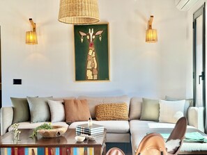 A modern living room with a sofa, a coffee table, and a wall-mounted artwork of a giraffe. - Kenz Essia Luxury Countryside Escape Near Tunis (Jedaida)