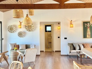 A spacious living area with a high ceiling, wicker pendant lights, a wooden ladder, and a painting on the wall. - Kenz Essia Luxury Countryside Escape Near Tunis (Jedaida)