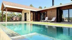 A modern house with a swimming pool, wooden exterior, and a chimney. - Kenz Essia Luxury Countryside Escape Near Tunis (Jedaida)