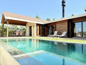 A modern house with a swimming pool, wooden exterior, and a chimney. - Kenz Essia Luxury Countryside Escape Near Tunis (Jedaida)