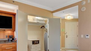 A hotel room with a built-in TV, a minibar, a walk-in closet with hanging clothes, and a door with a lock. - MGM Signature-09-704 Jacuzzi Studio (Las Vegas)