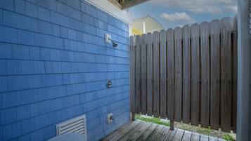 A blue exterior wall with a wooden deck and a wooden fence.