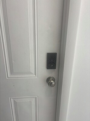 Una puerta blanca con teclado electrónico y cerradura.
