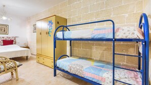A bunk bed with a wooden wardrobe and a single bed with a floral bedspread. - Villetta Lea by BarbarHouse (San Pietro in Bevagna)