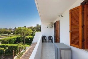 A balcony with a view of a green landscape, two chairs, and a small table. - Villino dei Saraceni by BarbarHouse (Torre dell'Orso)
