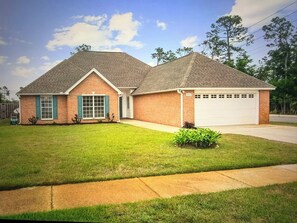 A two-story house with a garage, a well-maintained lawn, and a clear sky. - Beautiful Modern 3BR Home in Panama City (Panama City)