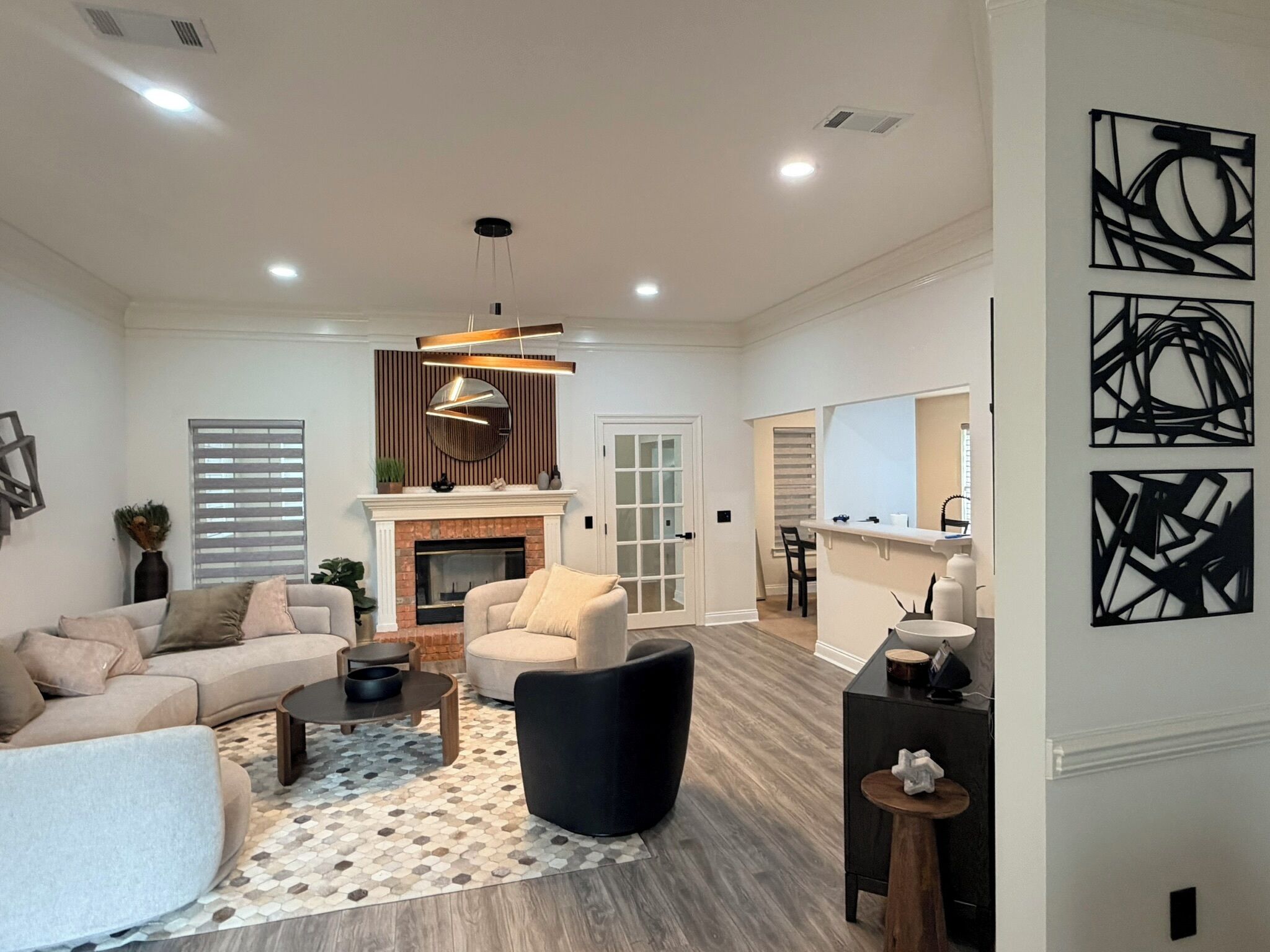 A spacious living room with a fireplace, a dining area, and a kitchen with modern appliances.