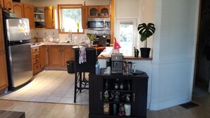 A modern kitchen with wooden cabinets, a stainless steel refrigerator, a microwave, and a coffee machine. - Otto Street, Osgoode. (osgoode)