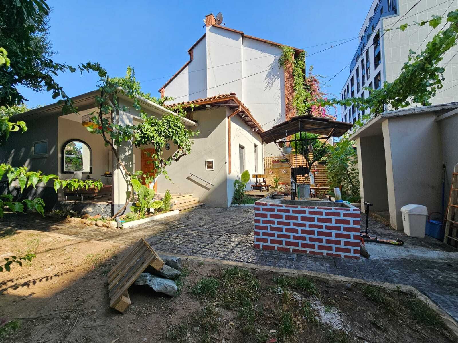 Une cour avec une structure en briques, un espace de repos abrité et un bâtiment doté d’un toit en tuiles.