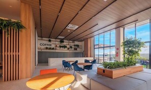 A modern coffee shop with a wooden ceiling, blue chairs, and a sign that reads 'COFFEE'. - Studio in Condo. w/ Pool Near the Beach Bea0207 (Salvador)