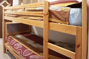 Ein Mehrstegbett mit mehreren Liegeebenen, jeweils mit einer Matratze und Kissen.