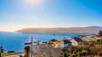 Une zone résidentielle côtière avec des maisons, un ciel dégagé et la mer.