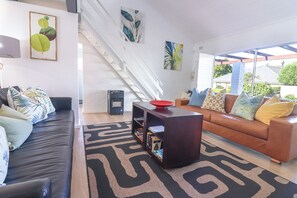 Ein modernes Wohnzimmer mit Treppe, einer Sofagarnitur und einem Couchtisch.