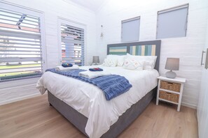 Ein Schlafzimmer mit einem Bett, Nachttischen und Blick durch das Fenster.