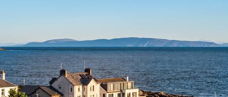Un quartier résidentiel situé sur la côte, avec des maisons à proximité de la mer, caractérisé par un mélange d’architecture moderne et traditionnelle.