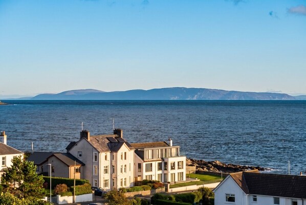 Un quartier résidentiel situé sur la côte, avec des maisons à proximité de la mer, caractérisé par un mélange d’architecture moderne et traditionnelle.