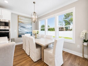 Eine moderne Küche mit Essbereich, großen Fenstern und Blick ins Freie.