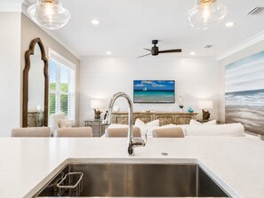A modern kitchen with a central island, a built-in sink, and a ceiling fan. - The Sandpiper Hideaway (Panama City Beach)
