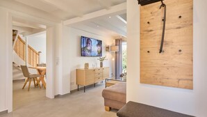 A modern interior with a staircase, dining area, and a wooden wall-mounted rack. - Vacation Home at Am Ringwal 82 in Cuxhaven Duhnen—modernized in 2026 with a Wallbox (Cuxhaven)