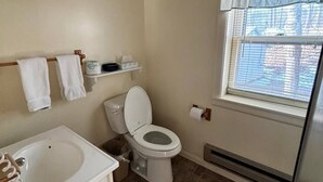 Un bagno con il water, un lavandino e una finestra.