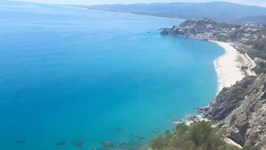 A coastal landscape with a clear blue sea, a sandy beach, and a settlement on a hillside. - Room 'Il Pero Selvatico, Doppia' with Shared Garden, Wi-Fi and Air Conditioning (Roccelletta)