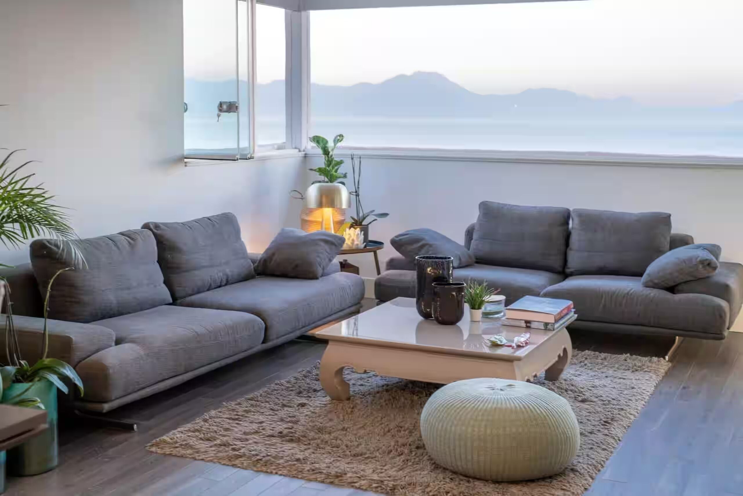 Un soggiorno moderno con divano, tavolino da caffè e vista sul mare.