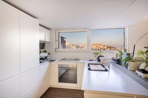 Eine kleine Küche mit Blick auf eine Stadtansicht durch ein Fenster.