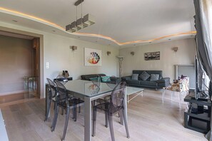 Ein modernes Wohnzimmer mit einem Glastisch, einer Couch und einem Fernseher.