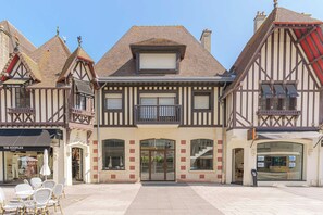 Ein traditionelles Fachwerkhäus mit einem zentralen Eingang, großen Fenstern und einem Balkon.