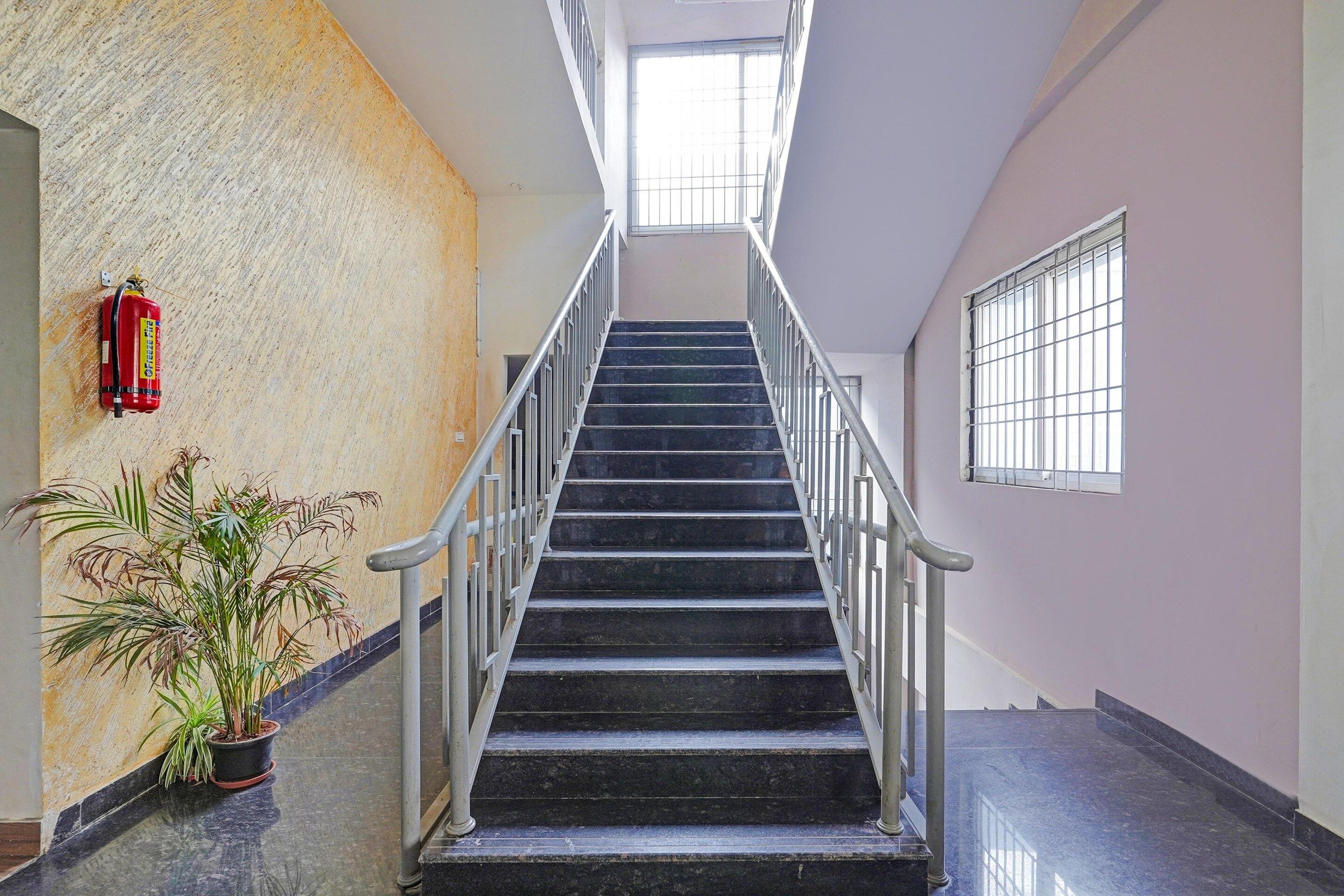 Un escalier avec des rampes métalliques menant à un palier.