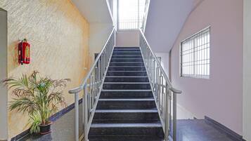 Un escalier avec des rampes métalliques menant à un palier.