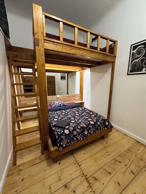A bunk bed with a wooden ladder, a single bed below, and a mirror on the wall. - Modern Karlín Apt III Old Town Walk III Metro 1 Min (Hlavní město Praha)