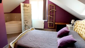 A bedroom with a bed, a window, a radiator, and a bathtub. - Air-conditioned Gîte "La Maison du Parc" with Private Pool near Nuits-Saint-Georges (Argilly)