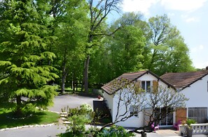 A residential area with a white house, a driveway, and a large tree. - Air-conditioned Gîte "La Maison du Parc" with Private Pool near Nuits-Saint-Georges (Argilly)