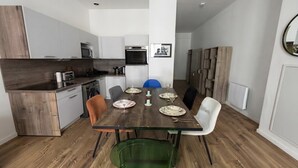 Eine moderne Küche mit Essbereich, Holzboden und einer zentralen Kochinsel.