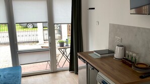 A compact kitchen with a dishwasher, a coffee maker, and a small dining table. - Apartment for 2 People Near the sea (Mielno)
