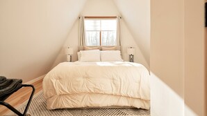 A bedroom with a bed, a window, and two bedside lamps. - Cozy, Private Dog-Friendly A-Frame Cabin: Mins to Hiking + Adorable Towns (Weathersfield)