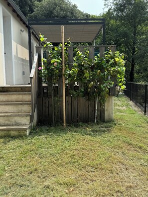 A residential property with a covered patio, a wooden fence, and a grassy yard. - House in the heart of nature (Gabriac)