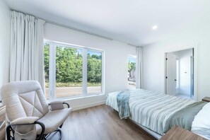 A bedroom with a bed, a chair, a window, and a door. - Nature & Mountain | Altisud (Saint-Philémon)