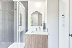 A modern bathroom with a glass shower enclosure, a wooden vanity, a large mirror, and a white sink. - Nature & Mountain | Altisud (Saint-Philémon)