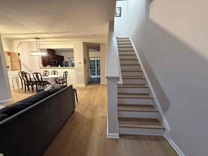 A modern interior with a staircase, a dining area, and a living room. - Spacious 4-bedroom townhome Cary/Morrisville area (Cary)