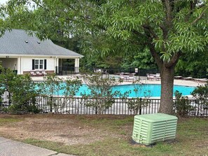 Una proprietà residenziale con piscina, patio coperto e giardino recintato.