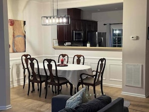A dining area with a round table, six chairs, and a pendant light. - Spacious 4-bedroom townhome Cary/Morrisville area (Cary)