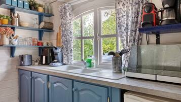 A kitchen with a window, a toaster, a coffee maker, and various kitchen utensils.