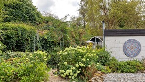 En have med forskellige planter og en dekorativ mur.