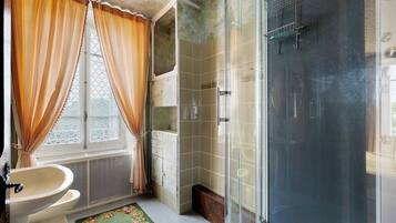 Een badkamer met een douchecabine van glas, een bad en een toilet.