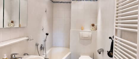 Moderni kylpyhuone, jossa on kylpyamme, pesuallas ja wc.