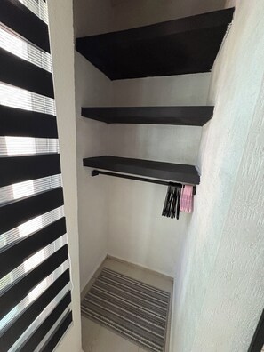 A corner with a black shelf, a white wall, and a vent. - Small house with a natural cenote in Playa del Carmen (Playa del Carmen)